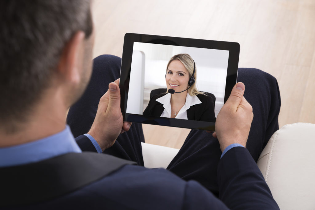 Businessman Video Conferencing With Businesswoman On Digital Tablet