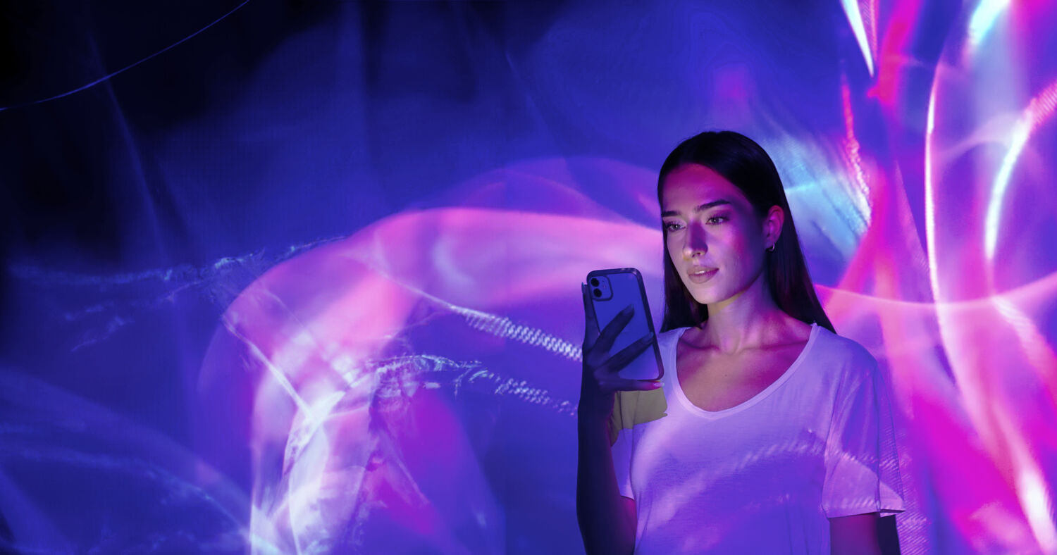 Image projection on a woman using a smart phone.